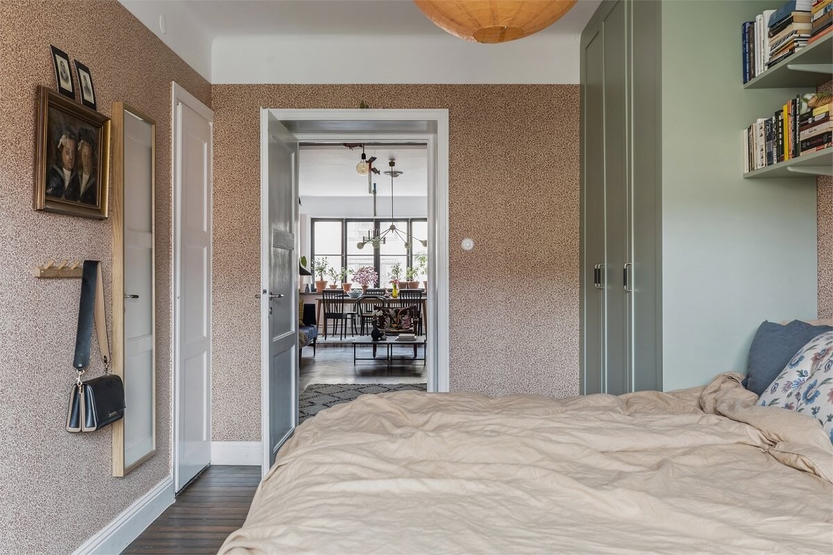 A Warm Scandinavian Apartment Filled with Books & Plants 12 master-bedroom-wallpaper-built-in-wardrobes-nordroom