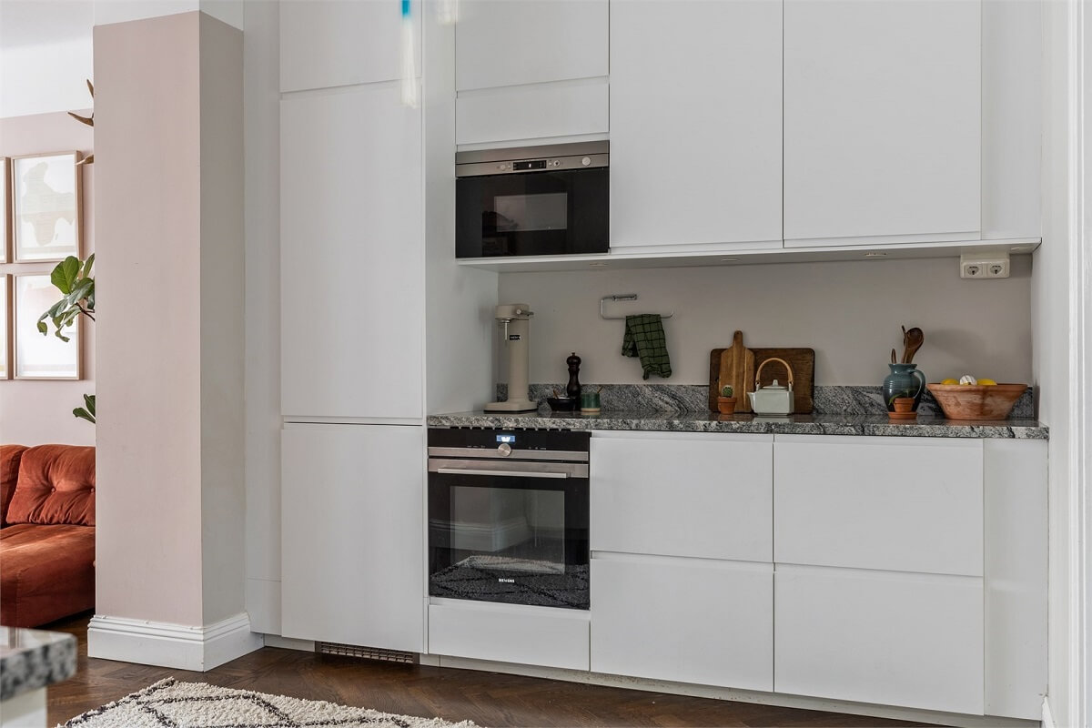 A Warm Scandinavian Apartment Filled with Books & Plants 8 modern-white-kitchen-cabinets-herringbone-floor-nordroom
