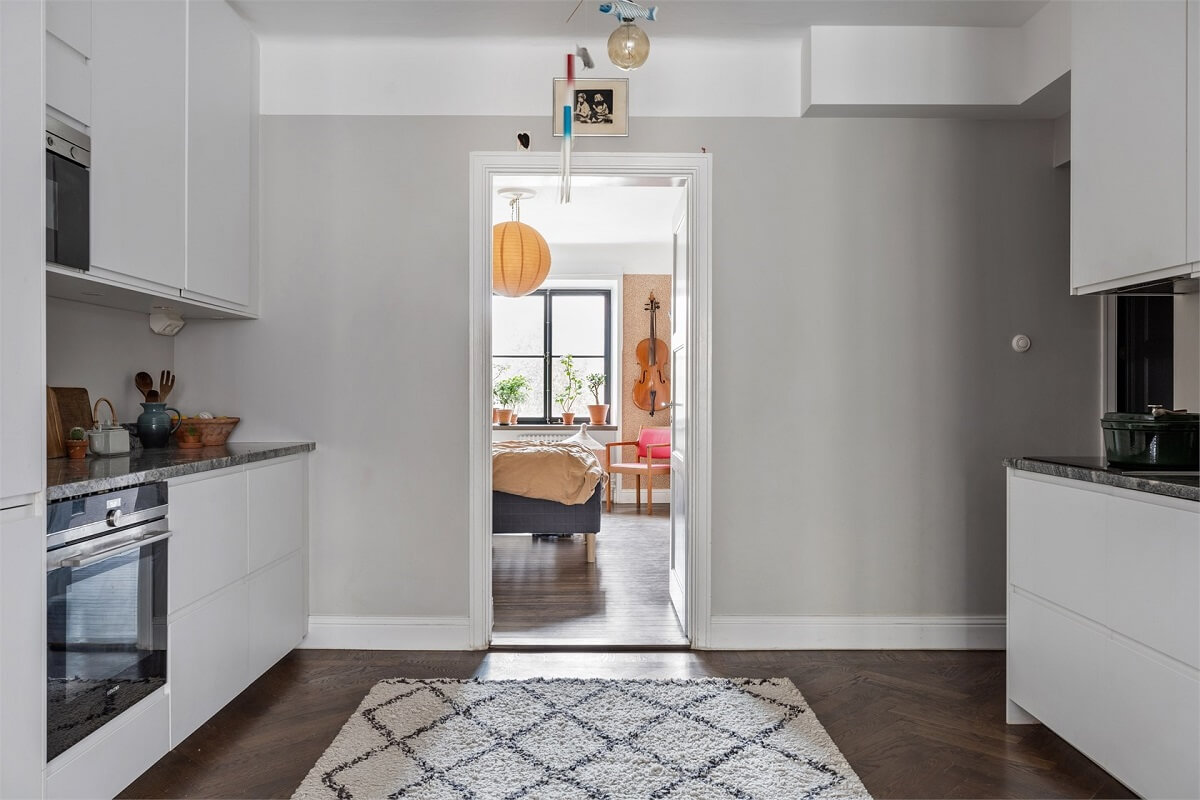 A Warm Scandinavian Apartment Filled with Books & Plants 9 modern-white-kitchen-herringbone-floor-nordroom