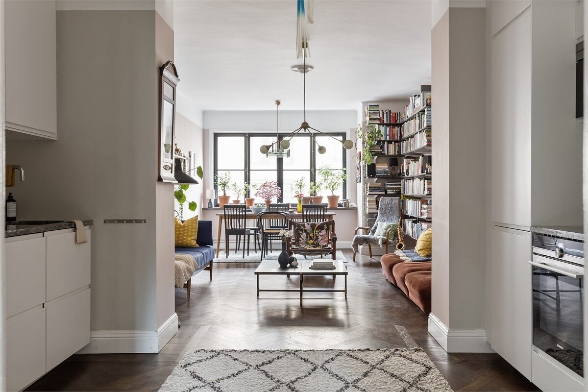 A Warm Scandinavian Apartment Filled with Books & Plants 7 open-plan-kitchen-living-room-white-cabinets-herringbone-floor-nordroom
