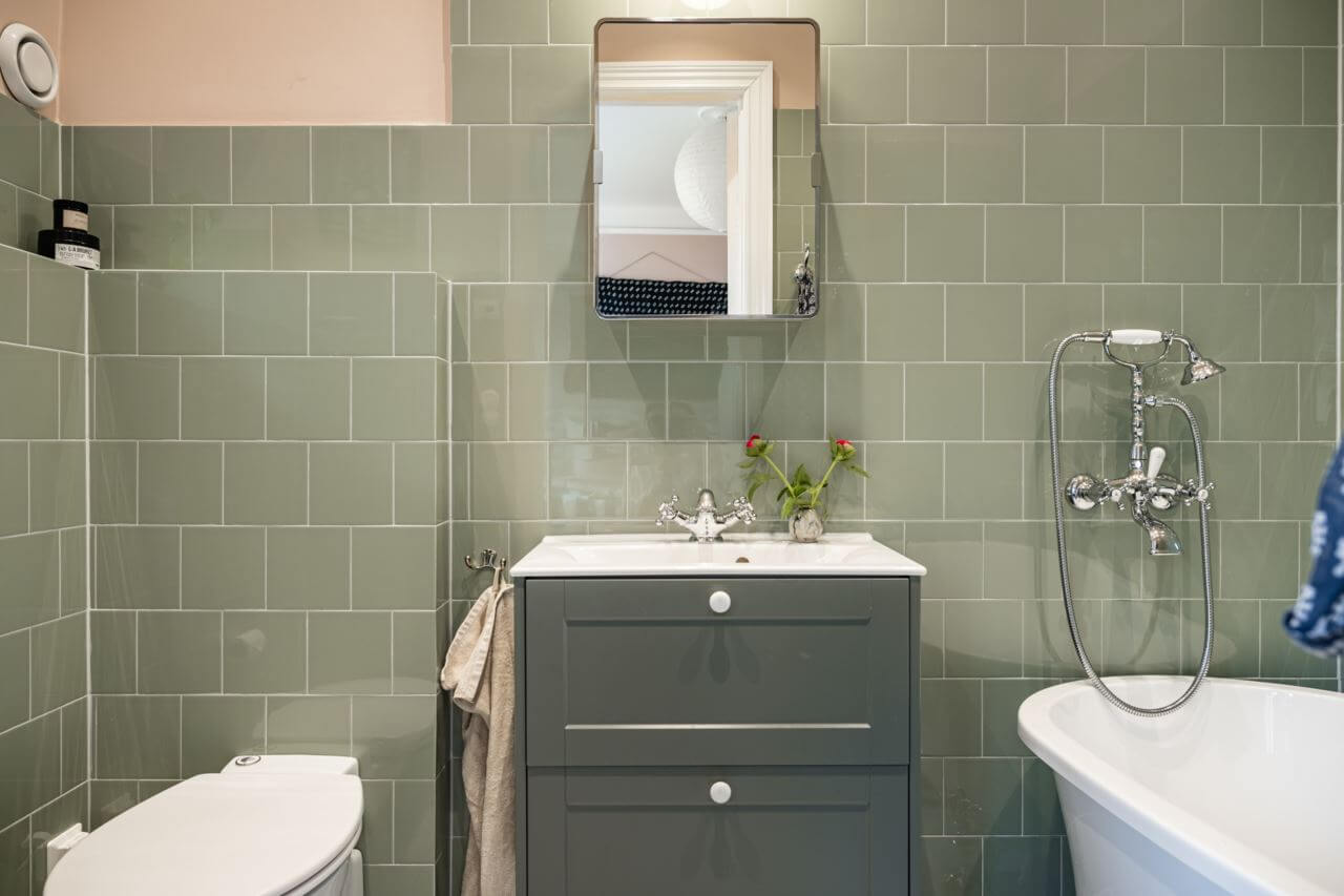 Green Color Accents in a Beautiful Historic Apartment 19 small-bathroom-green-tiles-bathtub-nordroom