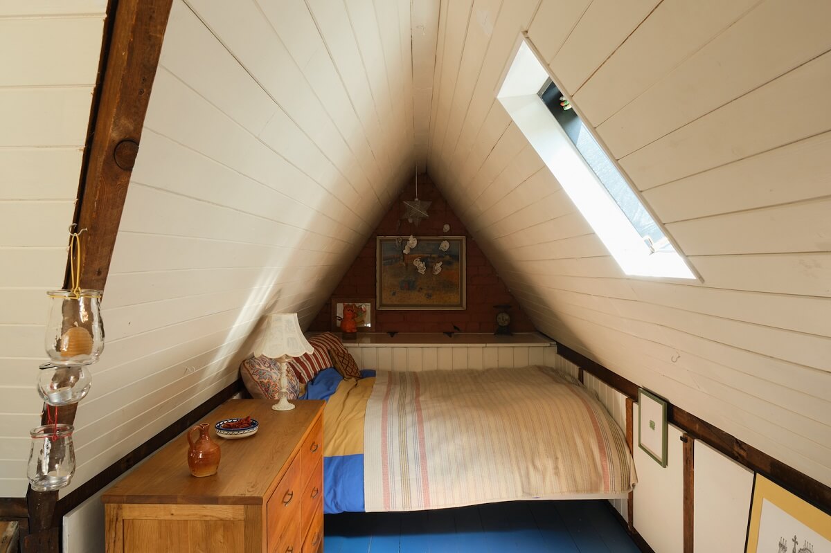 An English Cottage with Blue Color Accents 18 attic-bedroom-slanted-ceiling-blue-painted-floorboards-nordroom