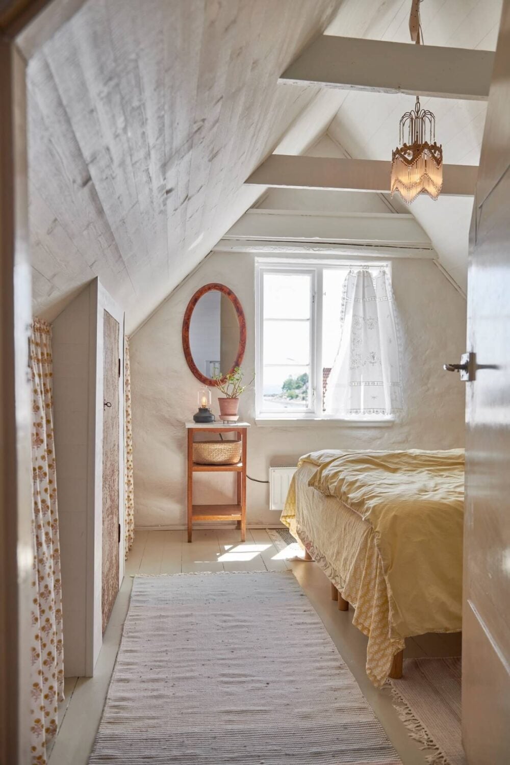 Natural Light in a Charming Swedish Country House 15 attic-bedroom-slanted-ceiling-yellow-bedding-nordroom