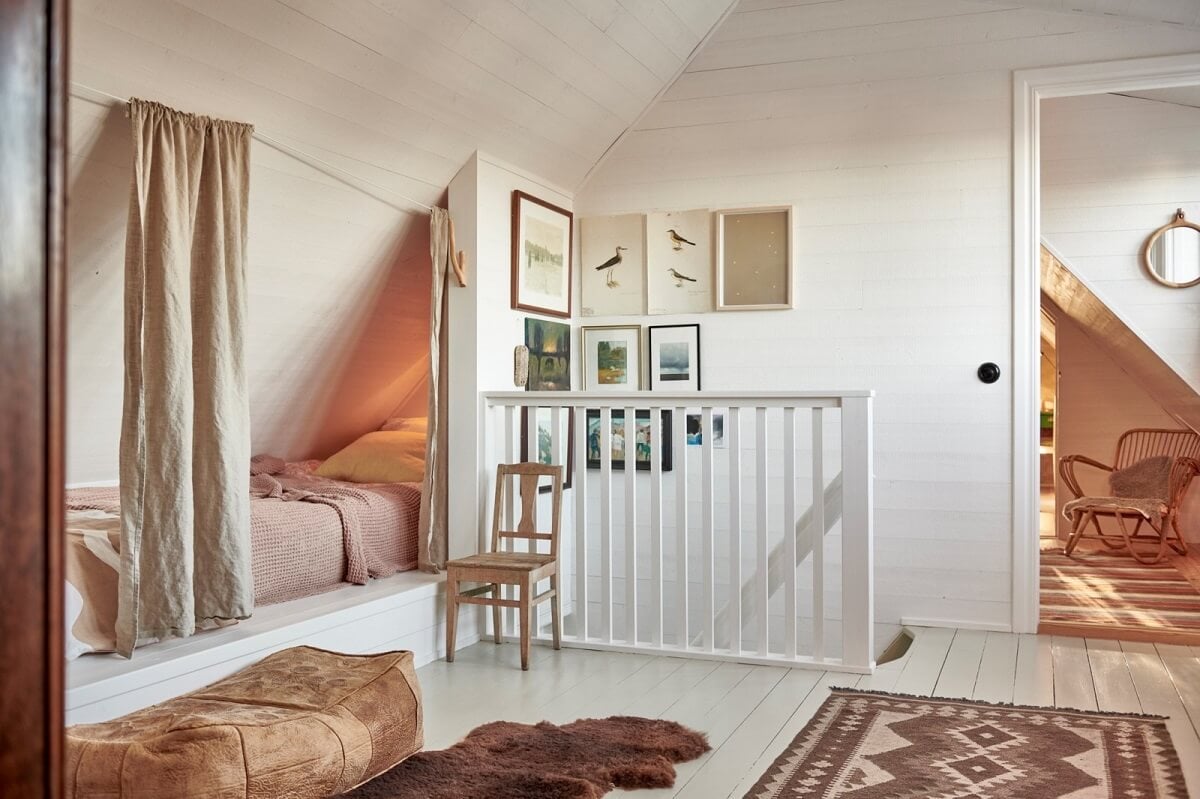 Natural Light in a Charming Swedish Country House 20 attic-room-bed-under-slanted-ceiling-curtain-nordroom