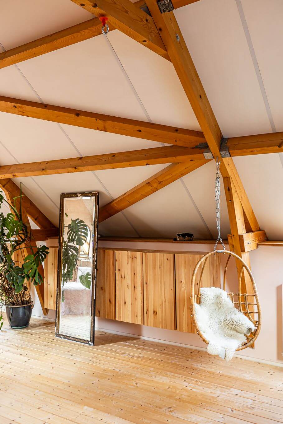 A Colorful Church Conversion in The Netherlands 26 attic-room-wooden-beams-rattan-hanging-chair-nordroom