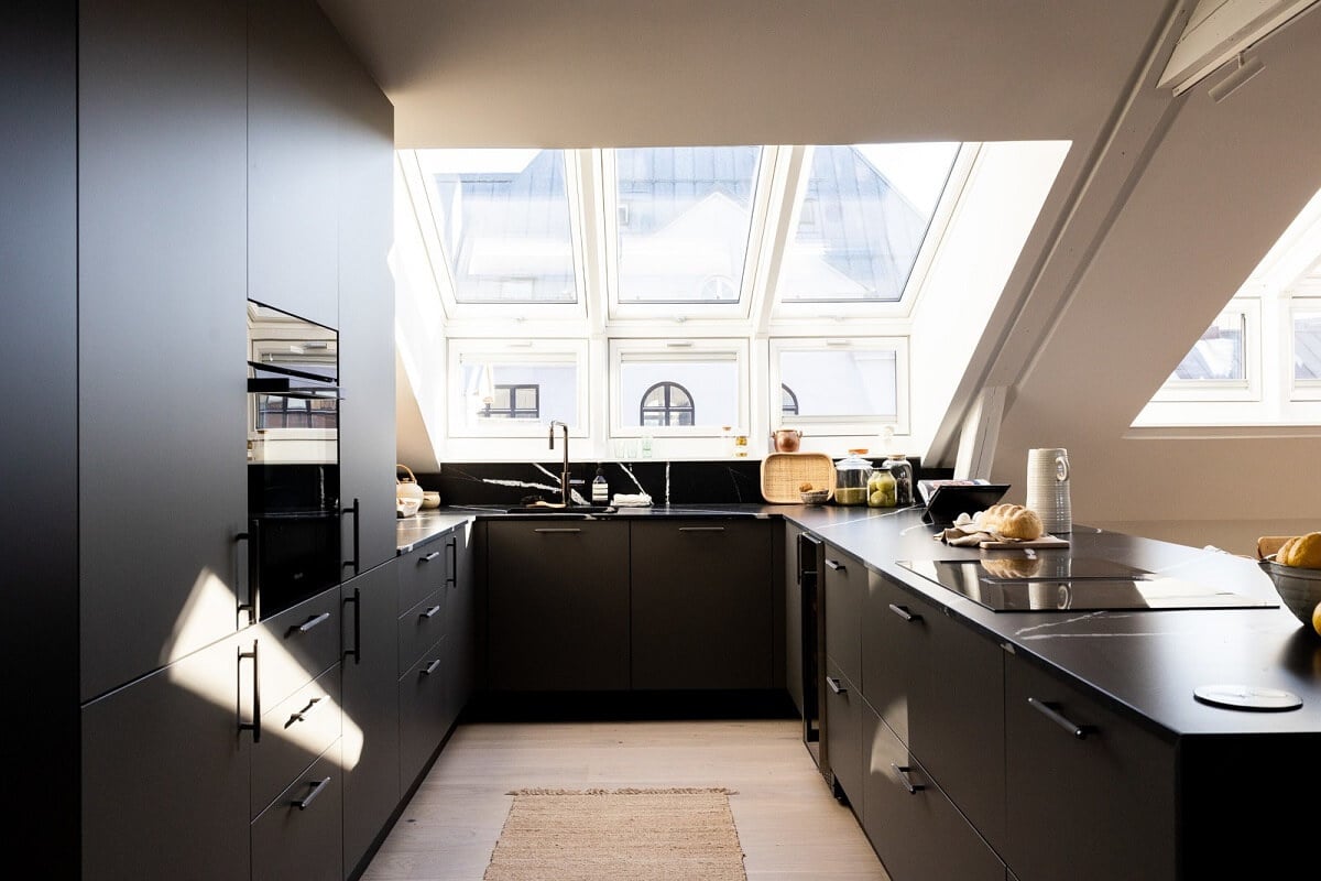A Bright Penthouse Apartment in Oslo 6 black-modern-kitchen-slanted-ceiling-skylights-nordroom
