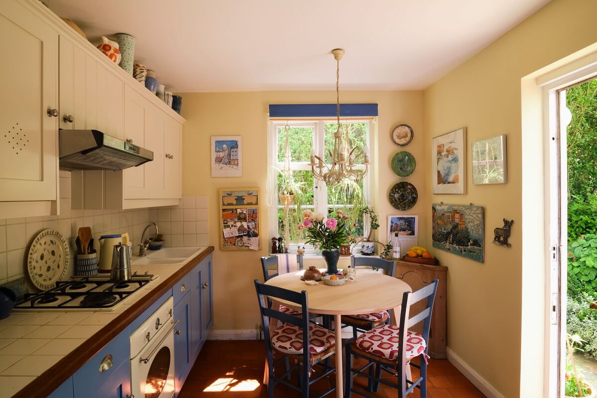 An English Cottage with Blue Color Accents 4 cottage-kitchen-blue-lower-cabinets-round-table-nordroom