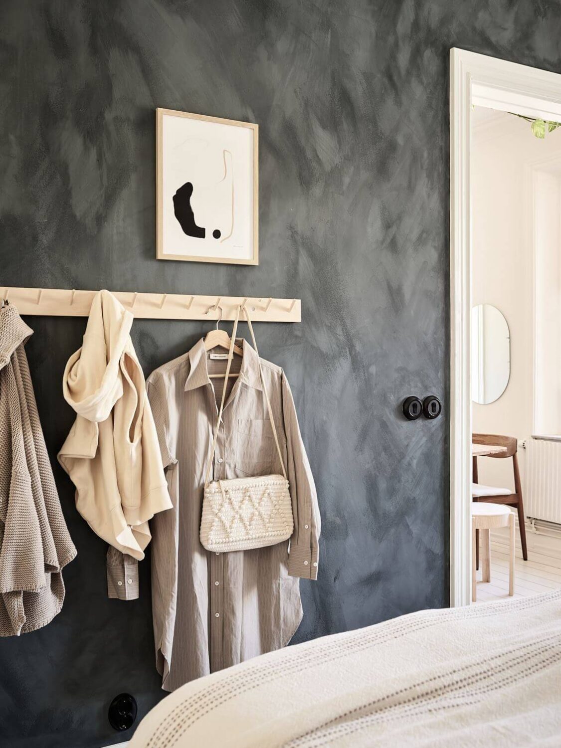 A Swedish Apartment with an Exposed Brick Wall 13 dark-gray-wall-clothing-rack-nordroom