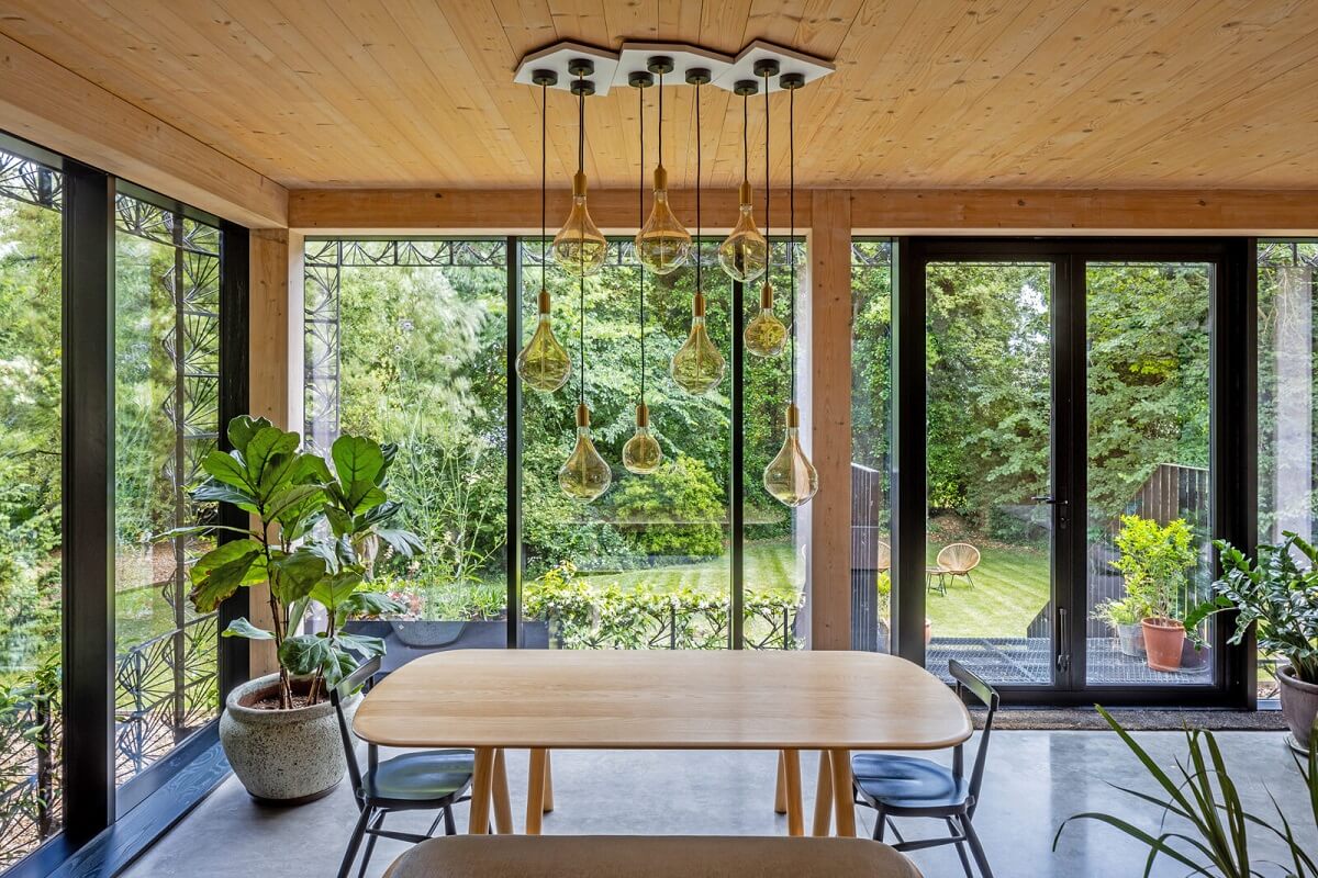 A Modern English Home with a Sculptural Facade 7 dining-area-wooden-ceiling-floor-to-ceiling-windows-nordroom