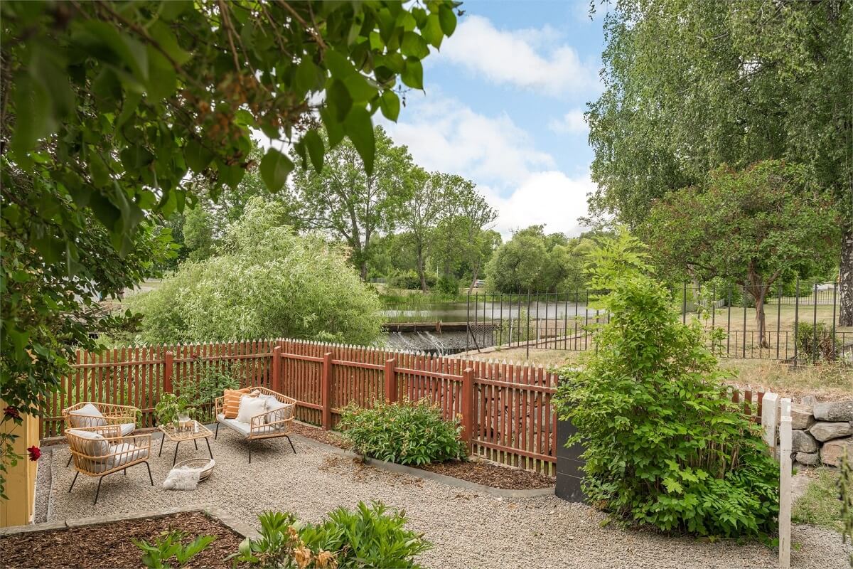 An Idyllic Small Swedish House with Wooden Beams 16 garden-seating-overlooking-canal-nordroom