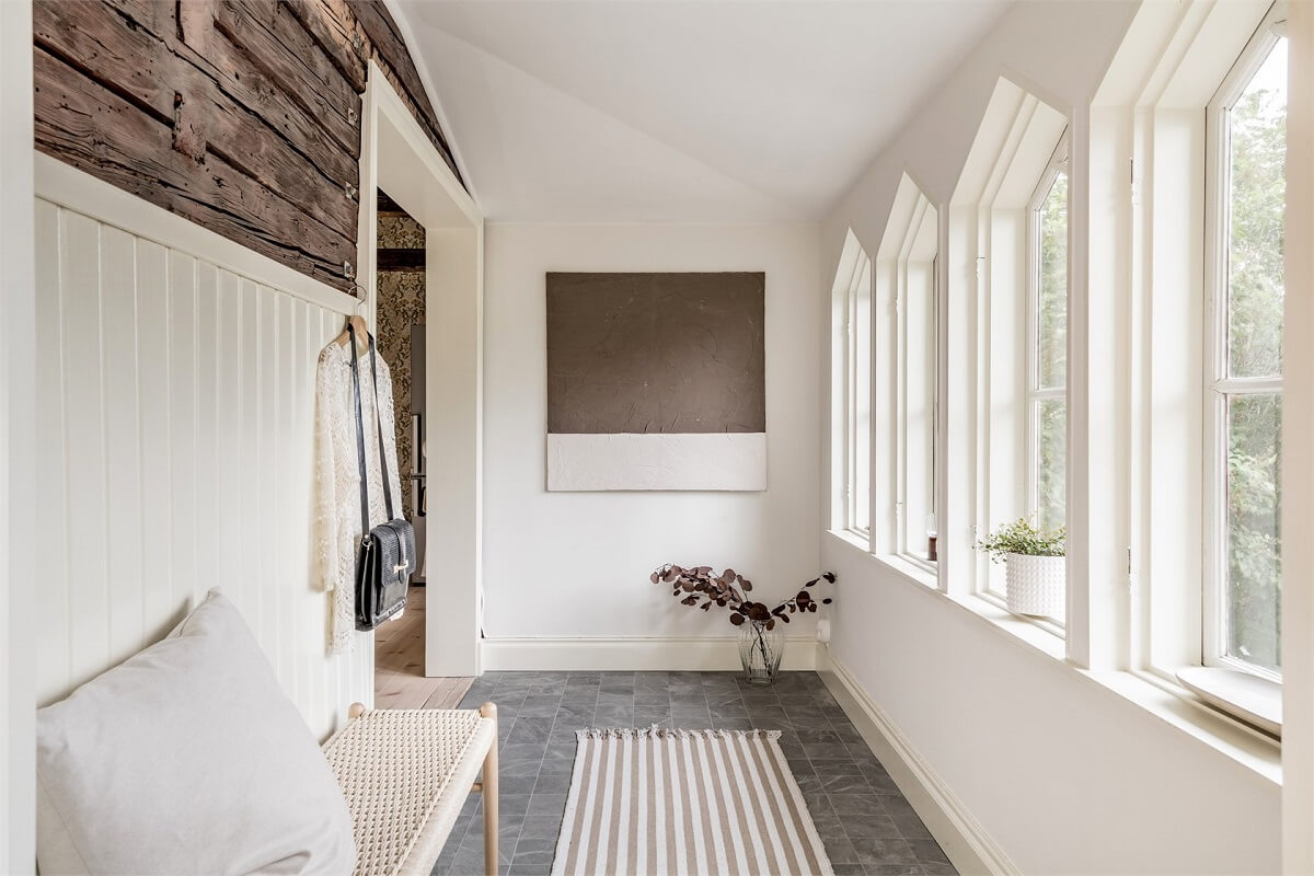 An Idyllic Small Swedish House with Wooden Beams 14 hallway-windows-stone-floor-rustic-wooden-accent-wall-nordroom
