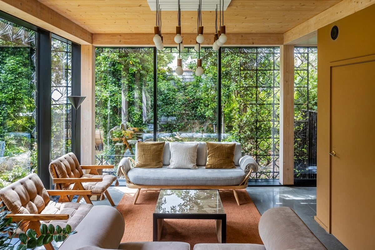 A Modern English Home with a Sculptural Facade 3 living-room-mustard-yellow-accent-wall-floor-to-ceiling-windows-nordroom