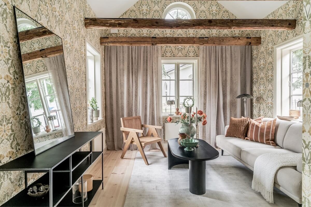 An Idyllic Small Swedish House with Wooden Beams 3 living-room-pitched-ceiling-wallpaper-round-window-nordroom