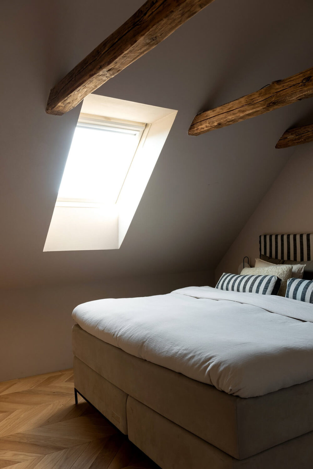A Luxurious Penthouse Apartment in Stockholm 23 attic-bedroom-wooden-beams-striped-headboard-nordroom