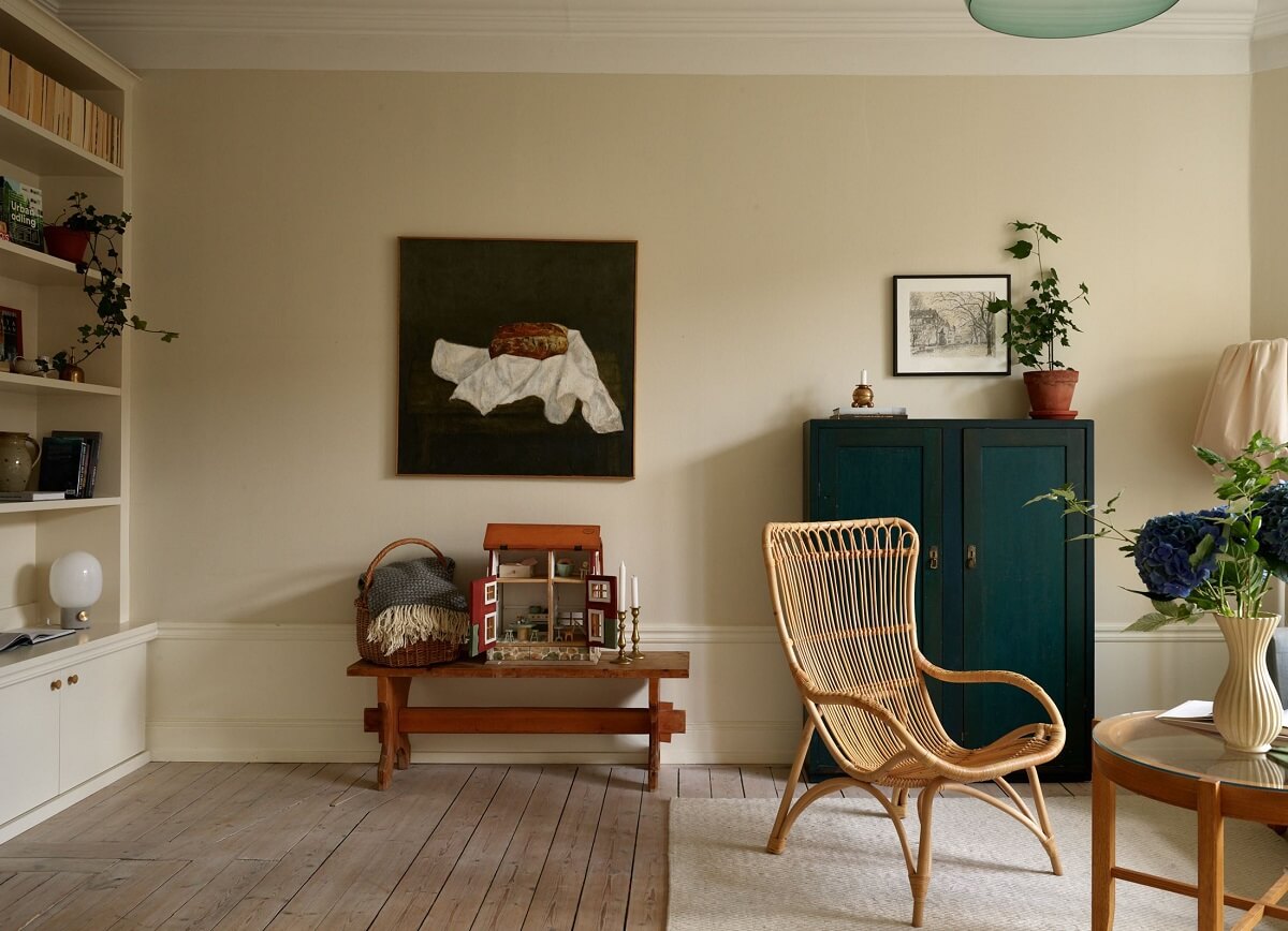 Beige Walls in a Serene Family Apartment in Sweden 2 living-room-beige-walls-rattan-chair-bookcases-nordroom