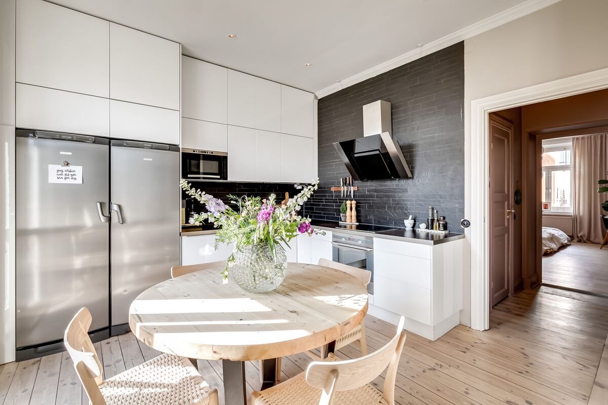 A Custom Headboard in a Light-Filled Swedish Apartment 15 round-table-white-kitchen-cabinets-black-tiles-nordroom