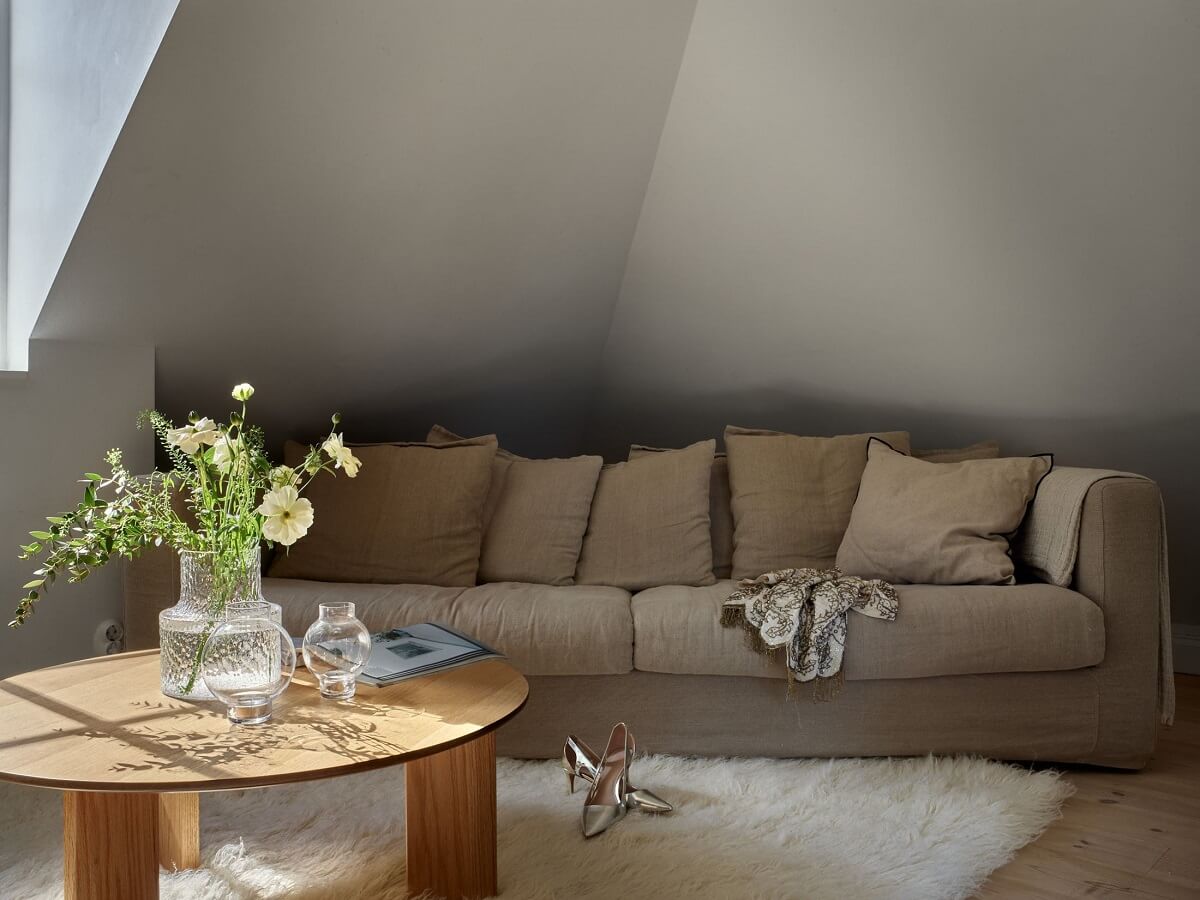 A Small Attic Apartment with Industrial Glass walls 3 sofa-under-the-slanted-ceiling-nordroom