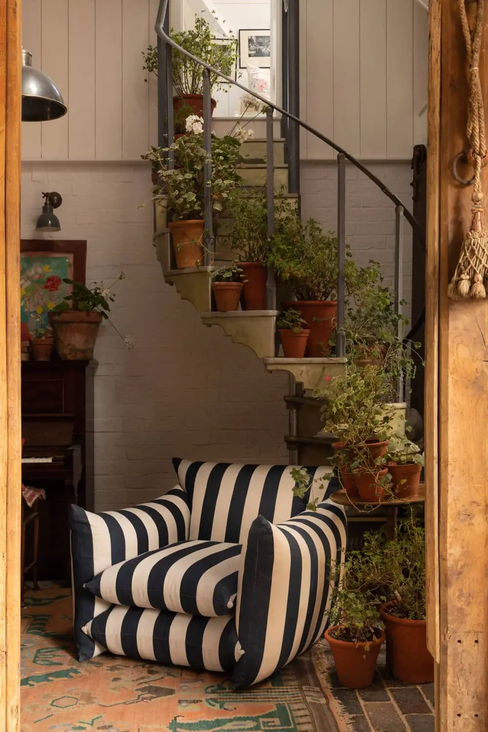Interior Design Trends for 2024: Comfort, Nature, and Warmth 31 striped-armchair-plants-spiral-staircase-interior-design-trends-nordroom