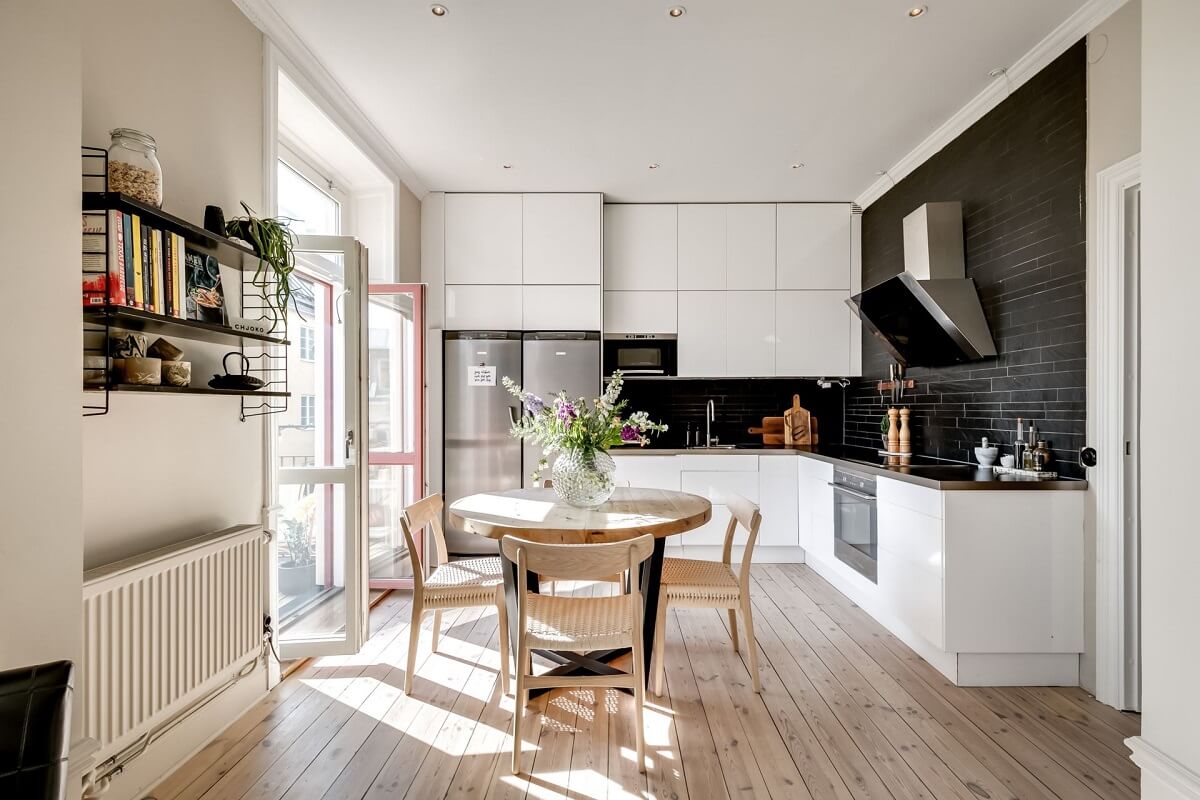 A Custom Headboard in a Light-Filled Swedish Apartment 10 white-kitchen-with-black-tiles-round-dining-table-nordroom