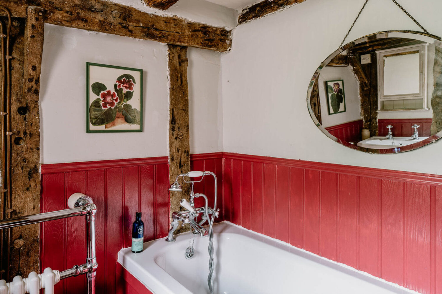 A Charming English Cottage with Color Accents 15 bath-red-painted-paneling-exposed-beams-nordroom