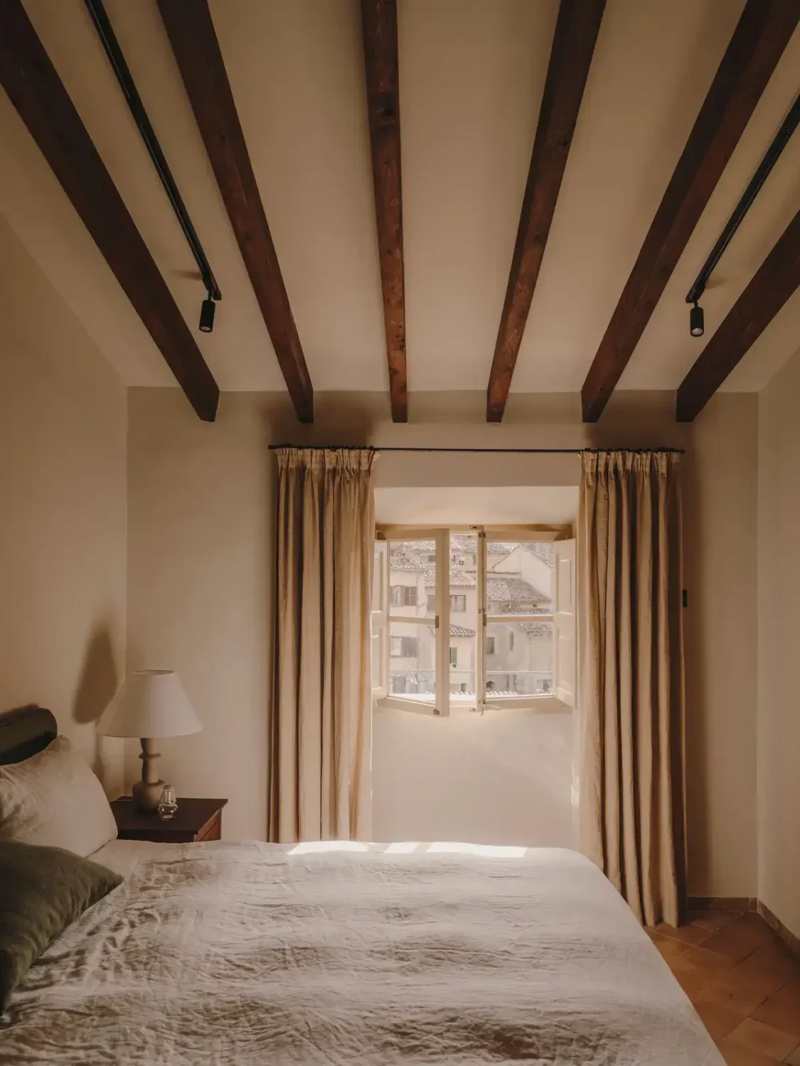 A Historic Townhouse on Majorca with a Striped Pool 19 bedroom-pitched-ceiling-wooden-beams