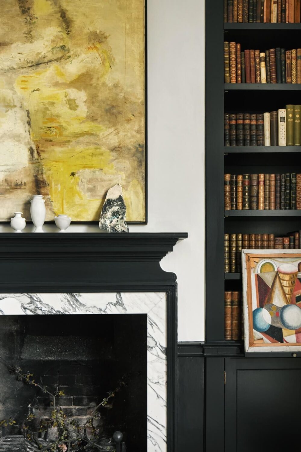 A Restored Georgian House with a Walled Garden 13 black-marble-fireplace-built-in-bookcase-yellow-artwork-nordroom