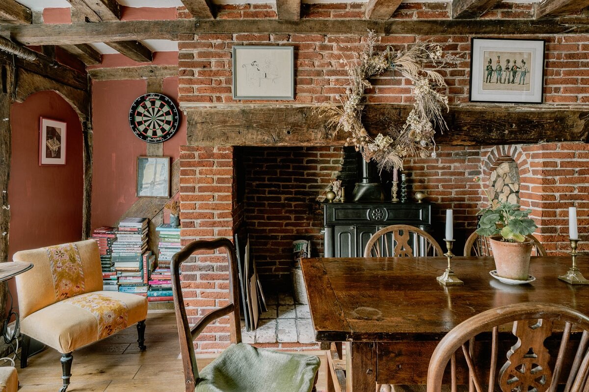 A Charming English Cottage with Color Accents 6 dining-room-exposed-beams-brick-walls-wooden-table-nordroom