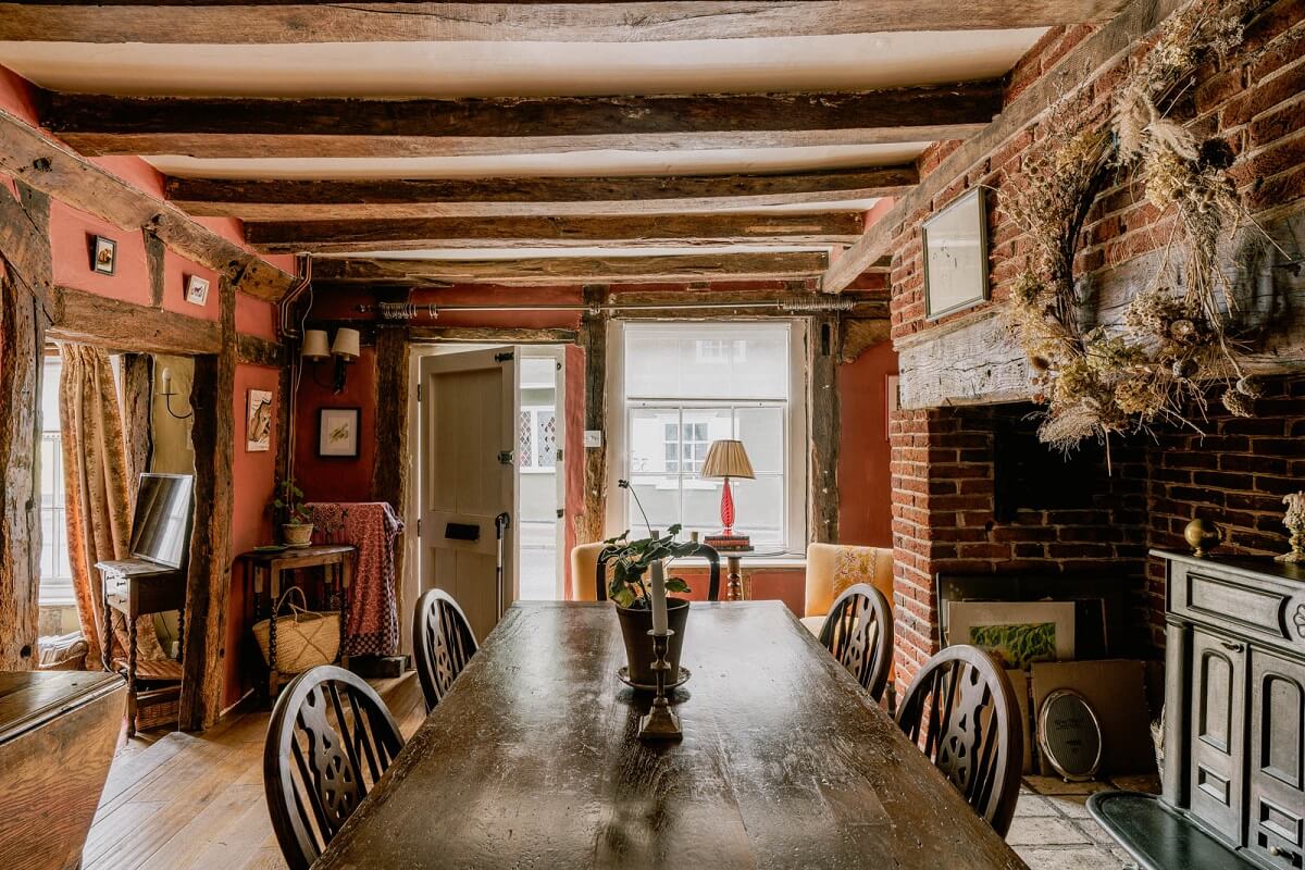 A Charming English Cottage with Color Accents 5 english-cottage-dining-room-pink-walls-exposed-beams-nordroom