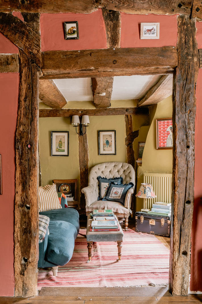 A Charming English Cottage with Color Accents 2 exposed-beams-pink-walls-cottage-living-room-nordroom