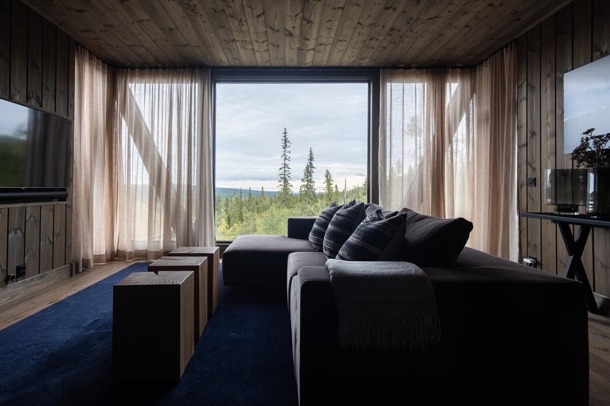 A Modern Rustic Log House in Sweden 10 floor-to-ceiling-windows-living-room-blue-rug-nordroom