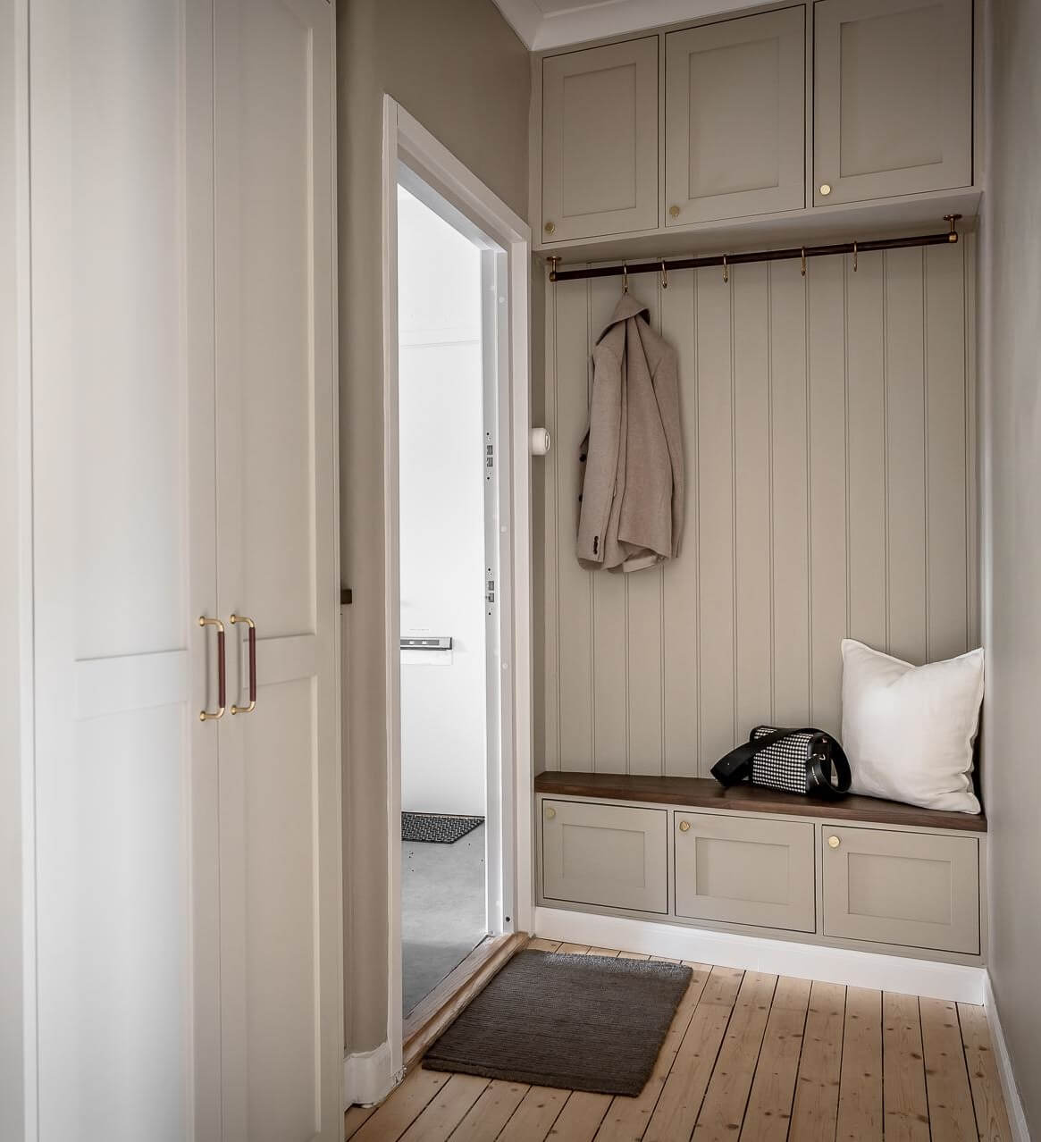 A Serene Studio Apartment with a Brown Kitchen 20 hallway-built-in-cabinets-bench-nordroom