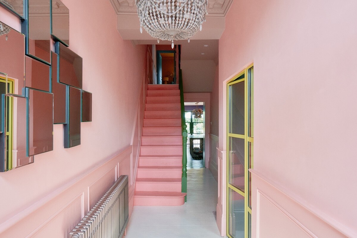 A Fun Colorful Family House in England 11 hallway-mirror-pink-walls-darker-pink-stairs-nordroom