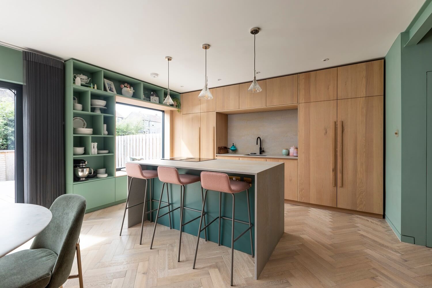 An Open-Plan Living and Kitchen in Green and Pink Tones 2 kitchen-oak-cabinets-island-pink-bar-stools-green-open-cabinets-agora-nordroom