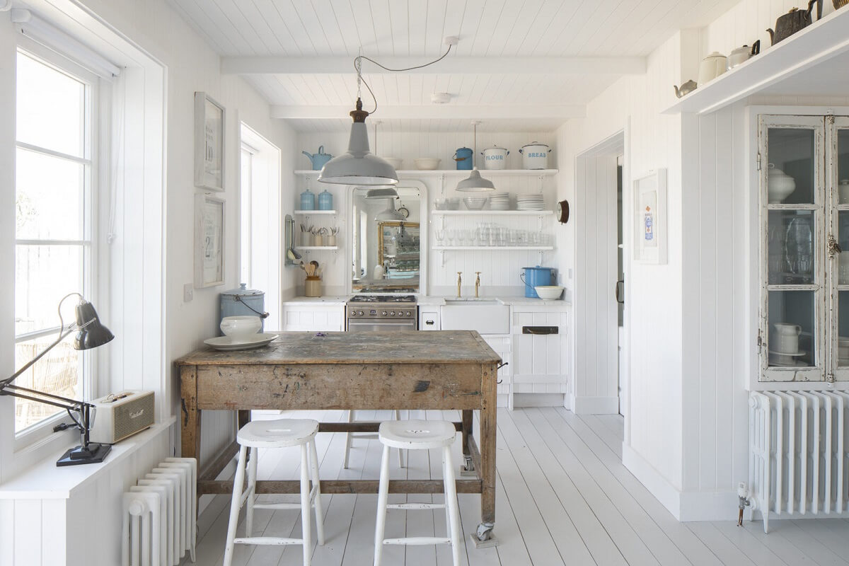 A Bright Coastal Home with Blue Color Accents in England 3 kitchen-rustic-wooden-island-with-bar-stools-nordroom