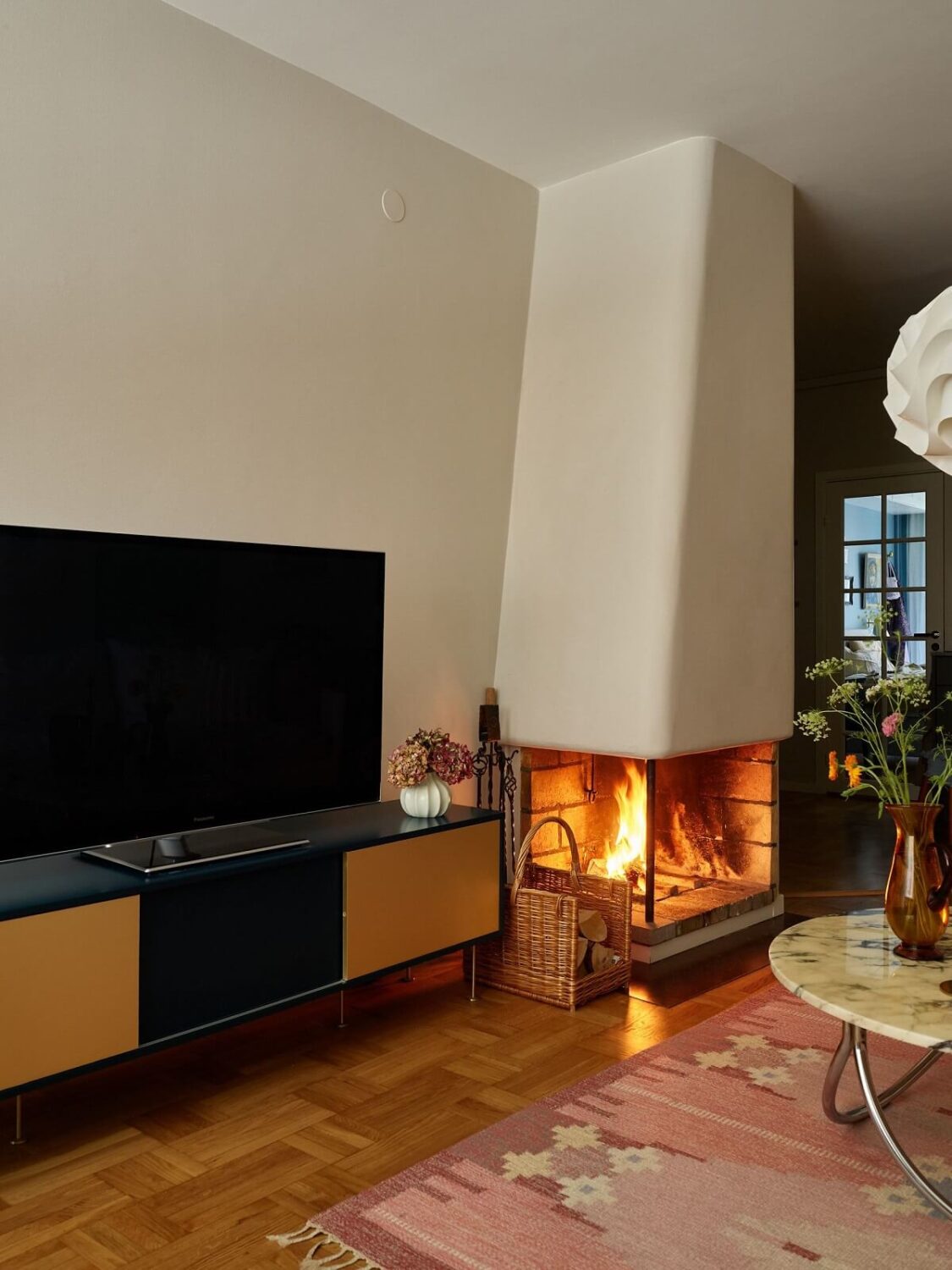 A Scandinavian Apartment with a Fresh Blue Bedroom 5 living-room-fireplace-pink-rug-nordroom