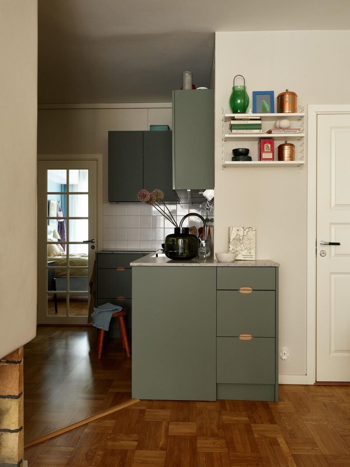 A Scandinavian Apartment with a Fresh Blue Bedroom 9 muted-green-kitchen-cabinets-nordroom