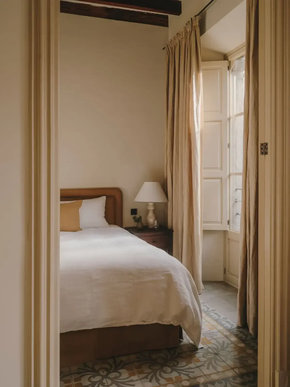 A Historic Townhouse on Majorca with a Striped Pool 23 ochre-yellow-bedframe-floor-tiles-nordroom