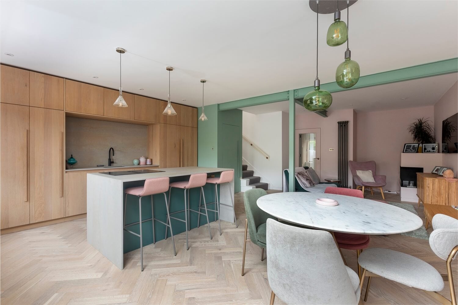 An Open-Plan Living and Kitchen in Green and Pink Tones 9 open-plan-living-kitchen-round-dining-table-kitchen-island-bar-green-accents-nordroom