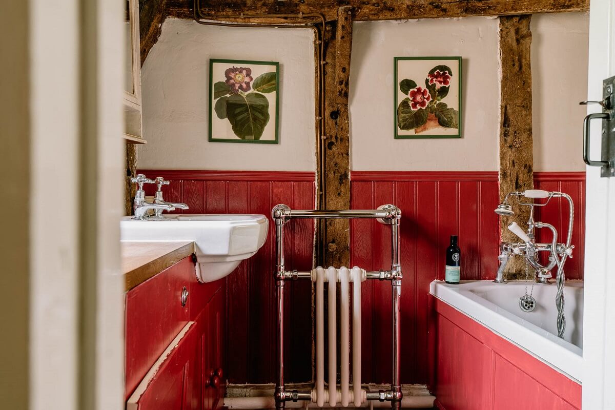 A Charming English Cottage with Color Accents 14 red-bathroom-exposed-wooden-beams-nordroom