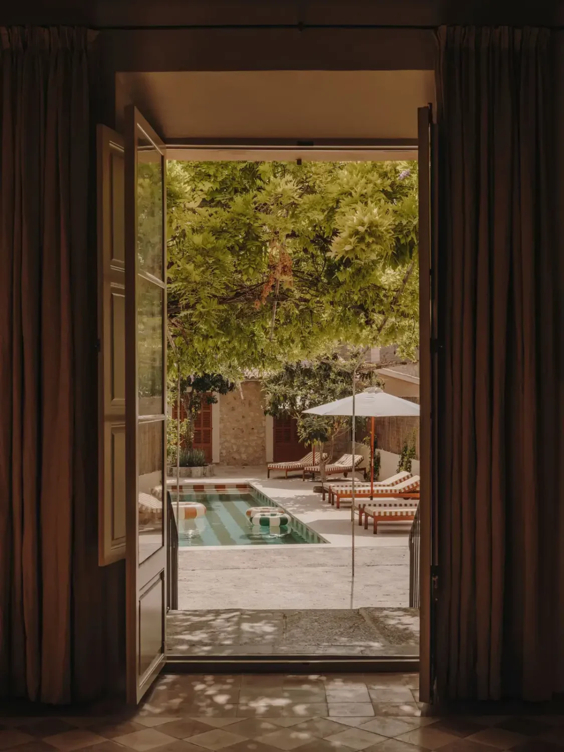 A Historic Townhouse on Majorca with a Striped Pool 29 view-into-garden-with-pool-nordroom