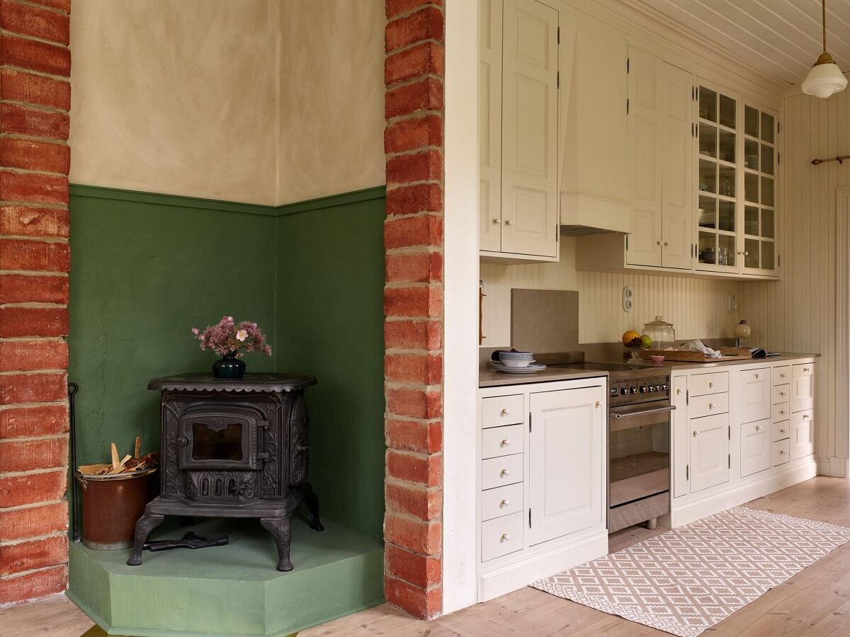 A Beautiful Swedish Country House with a Large Garden 4 woodburner-cream-kitchen-cabinets-nordroom