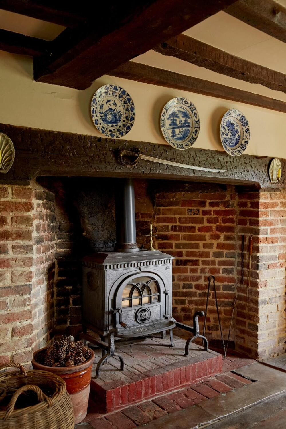 A Charming Historic Farmhouse with a Bright Yellow Kitchen 14 brick fireplace exposed beams cottage