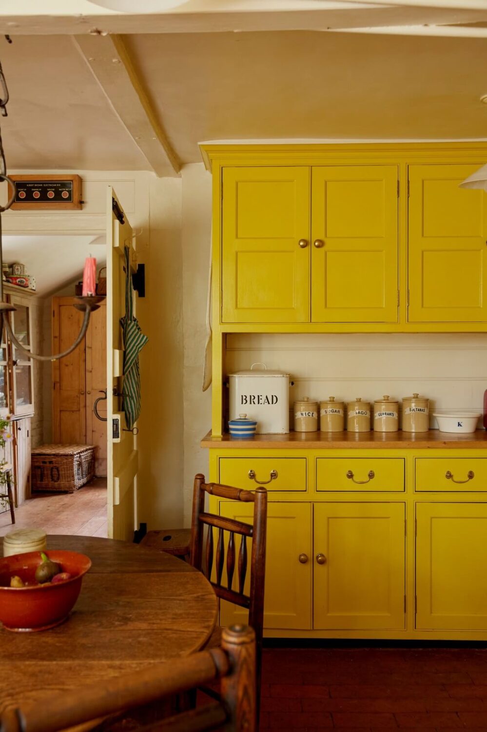 A Charming Historic Farmhouse with a Bright Yellow Kitchen 9 bright yellow kitchen cabinets stone floor
