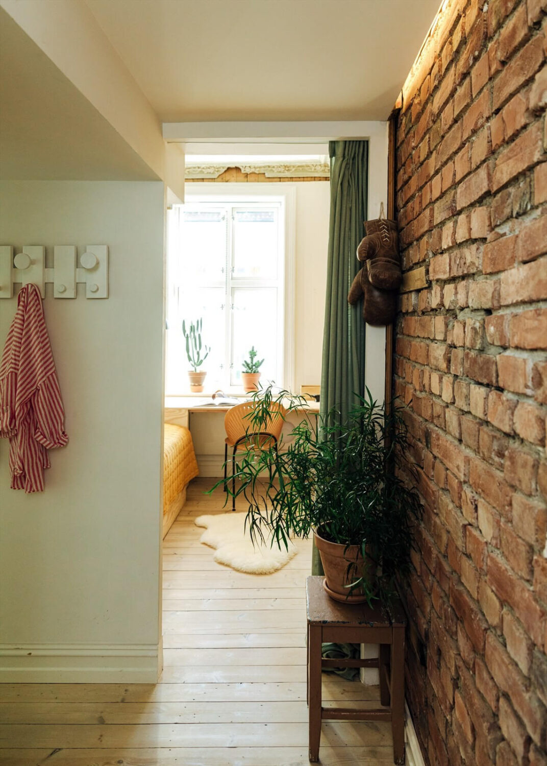 A Charming Norwegian Apartment with Wooden Walls 17 exposed-brick-wall-curtain-entry-bedroom