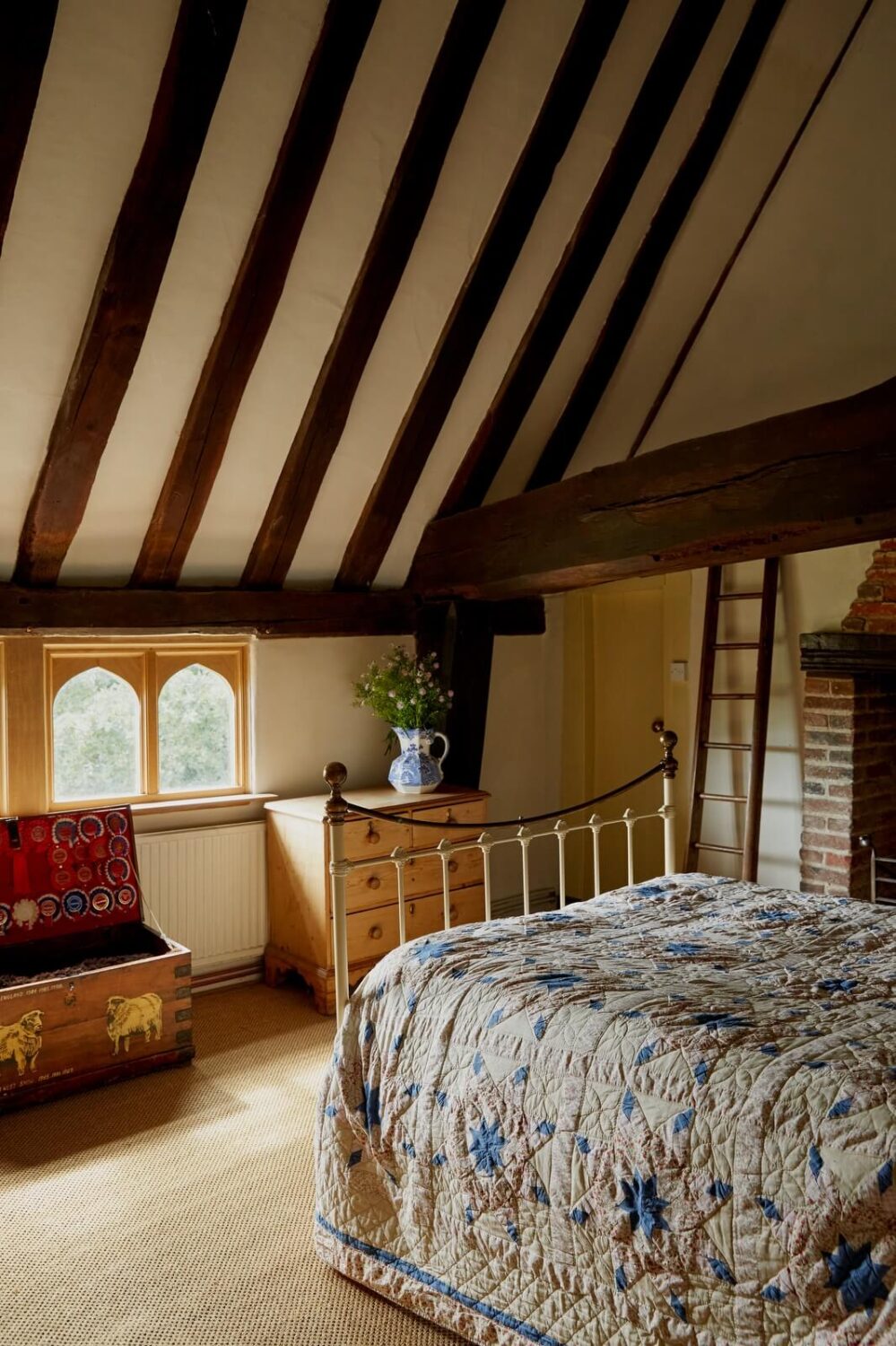 A Charming Historic Farmhouse with a Bright Yellow Kitchen 18 exposed wooden beams slanted ceiling bedroom