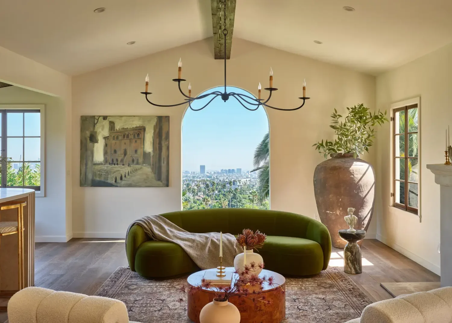 A Renovated Spanish Style Home in Hollywood Hills 6 green-curved-sofa-arched-window-large-plant-pot-nordroom