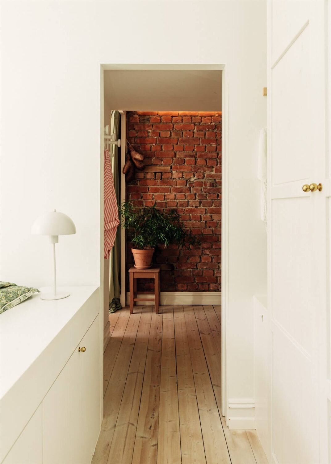 A Charming Norwegian Apartment with Wooden Walls 16 hallway-wooden-floorboards-exposed-brick-wall-nordroom