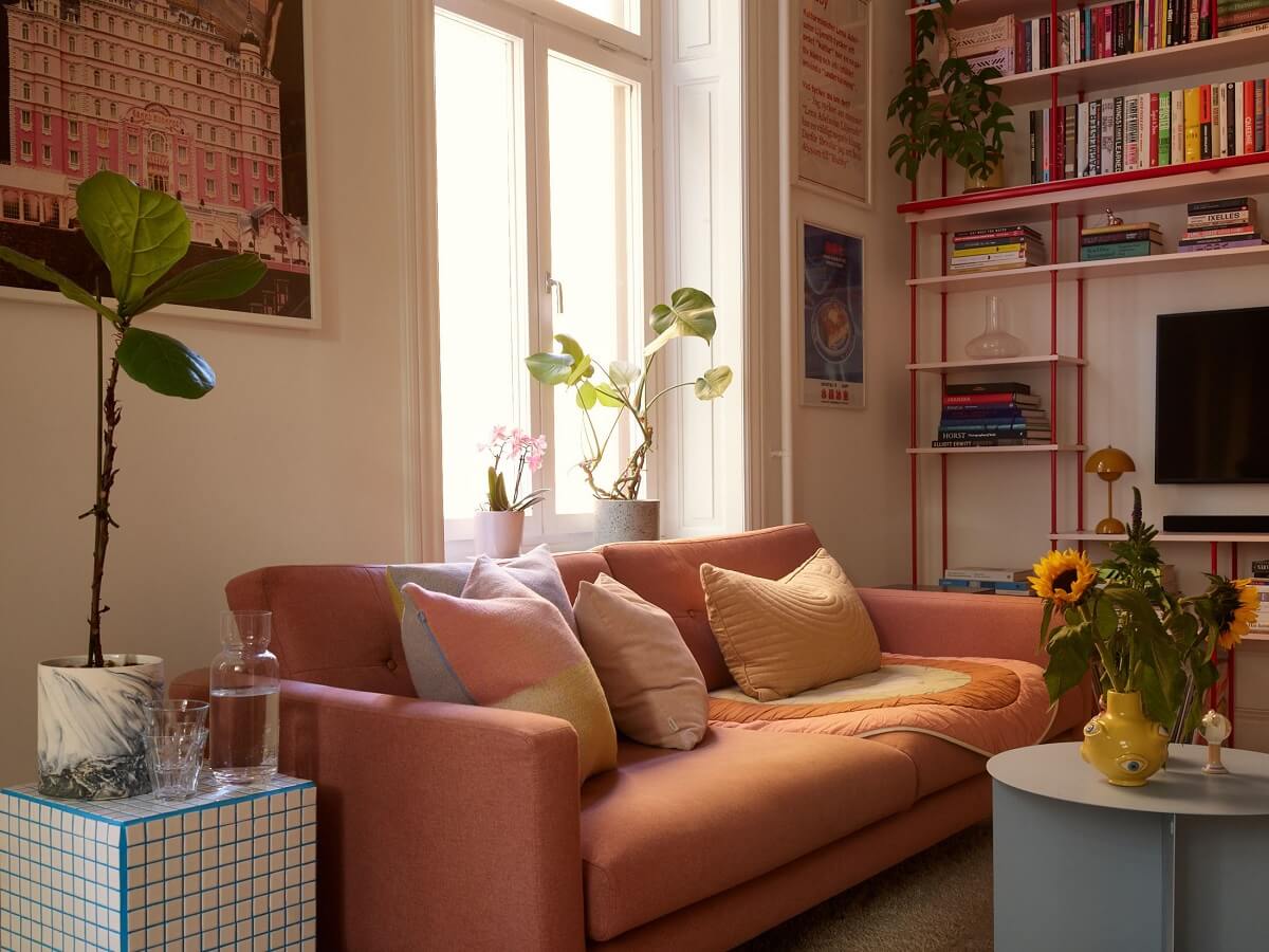 A Small Stockholm Apartment Filled with Color 3 living-room-pink-sofa-red-bookshelves-nordroom