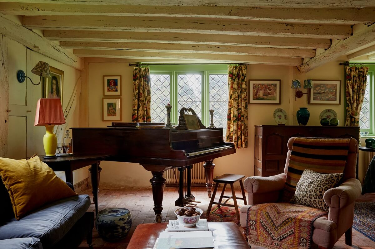 A Charming Historic Farmhouse with a Bright Yellow Kitchen 5 low ceiling with beams cottage living room piano