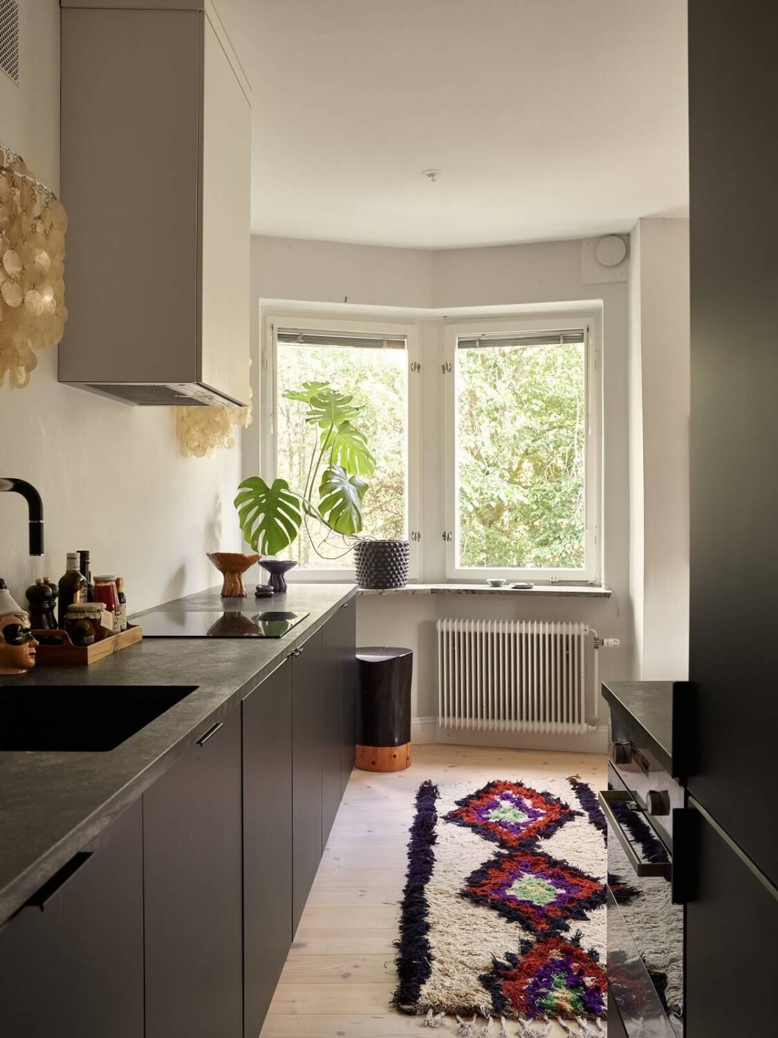 Warm Pink Tones in A Stockholm Apartment 10 modern-black-kitchen-rug-nordroom